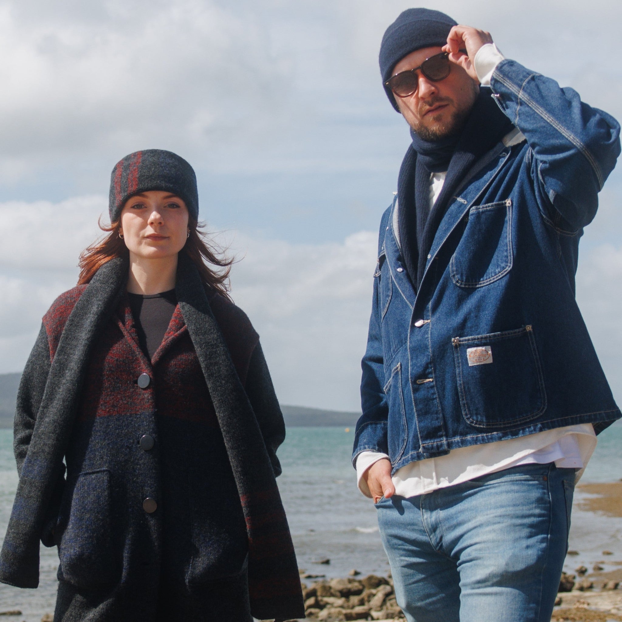 Boy and girl models on pier both wearing cuffed beanies and scarves