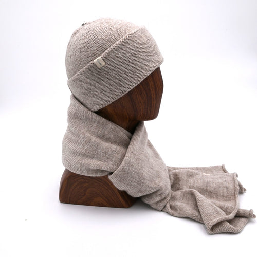 Mannequin wearing an Oatmeal Andes cuffed beanie with a subtle pattern, made of alpaca and merino wool matching Scarf. (Prof)