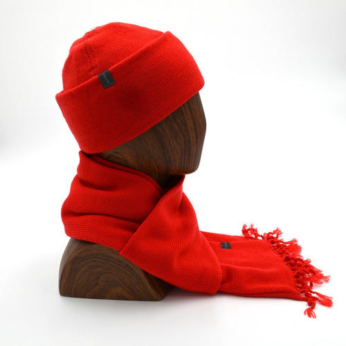 profile mannequin wearing an poppy cuffed toque with a matching tassel scarf