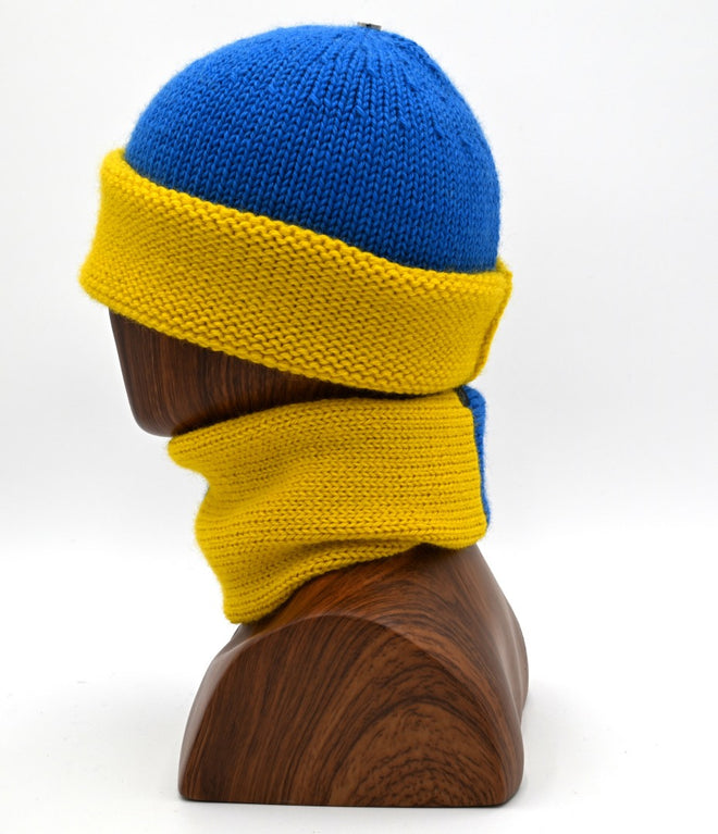 A Marble Cuffed toque Shaka and scarf set, with a blue/yellow Toque and matching scarf, displayed on a wooden mannequin head.