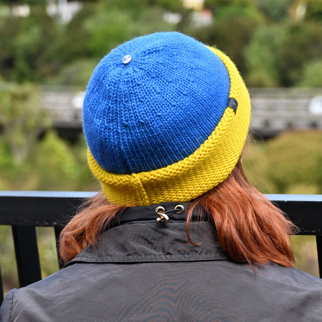 A model seen from the back wearing a Toque and Cowl scarf in blue and yellow, supporting Ukraine's national colors.