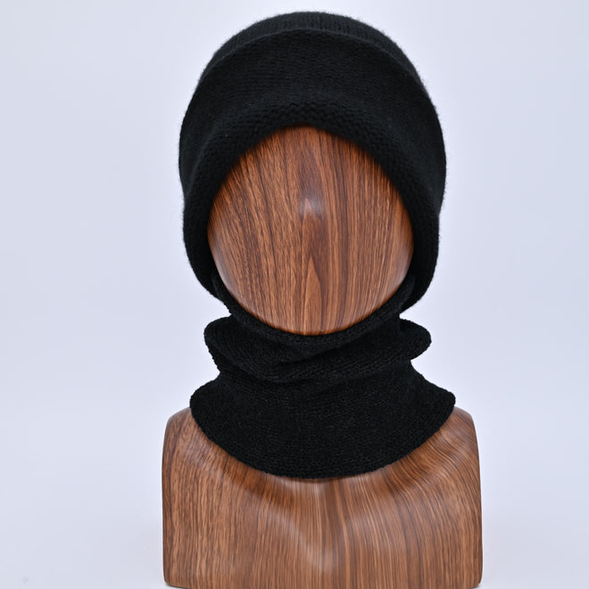 Black knitted balaclava on a wooden mannequin head against a light gray background