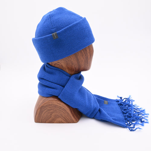 profile mannequin wearing an azure blue cuffed toque with a matching tassel scarf