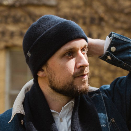 A model wearing a Midnight Navy Sub-21 felted toque and matching scarf  Both made of lambswool.