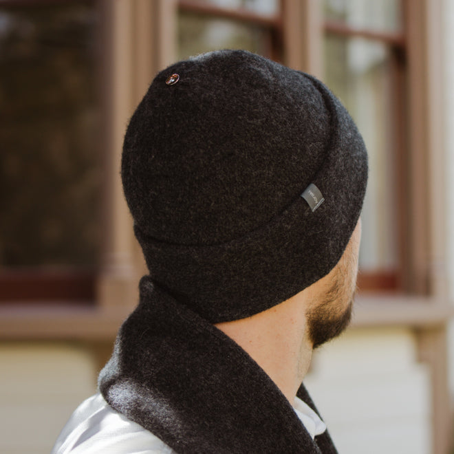 Model wearing a Gunmetal Sub-21 Felted Toque featuring a silver Bean at its peak. Matching Classic 1800 Scarf