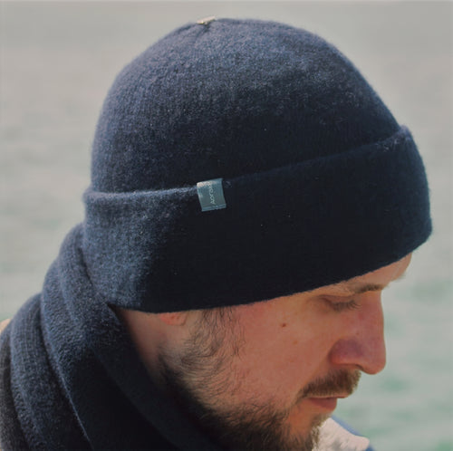 A model wearing a Midnight Navy Sub-21 felted toque and matching Classic scarf.  Both made of lambswool.