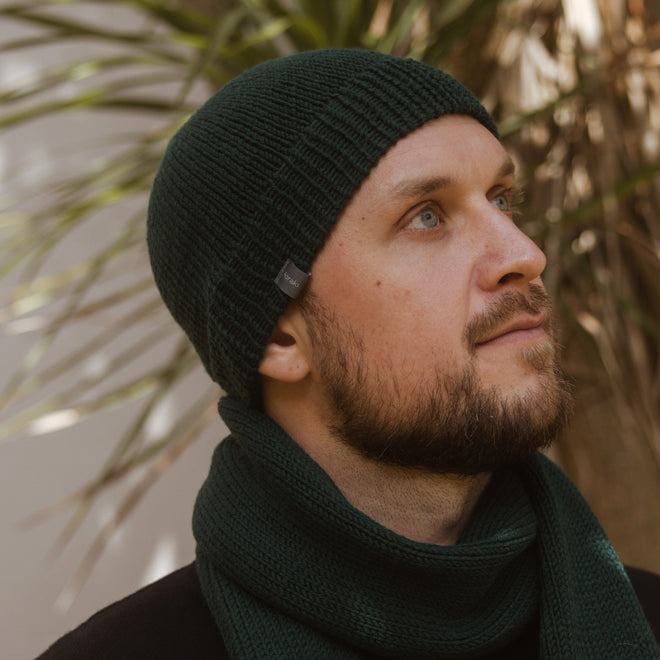 A model wearing a Ruapehu Classic Merino Beanie with a Classic Scarf both in Shamrock Green