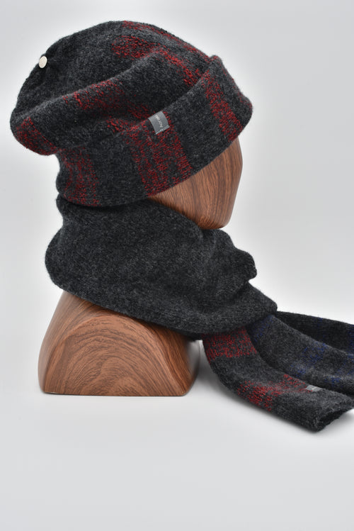 A mannequin wearing a dark gray tri-stripes felted slouchy with a cuffed design, and matching RGB 1800 scarf. Profile