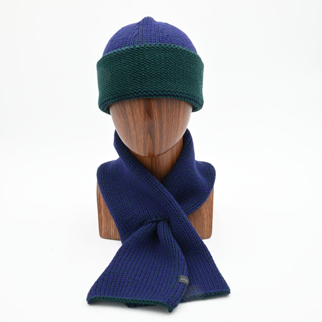 A mannequin wearing a marbled Cuffed Toque in Oxen. The Toque features a silver bean at the crown. This is shown here with a matching Ascot Scarf.