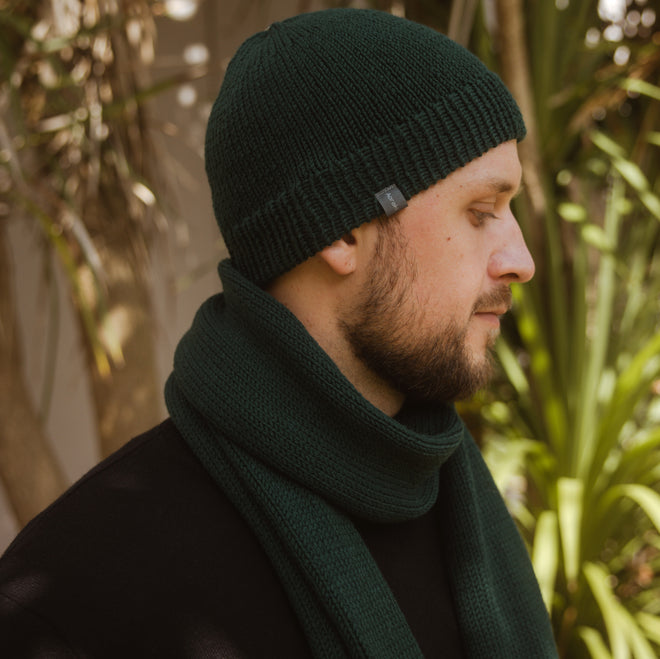 A model wearing a Ruapehu Classic Merino Beanie with a Classic Scarf both in Shamrock Green