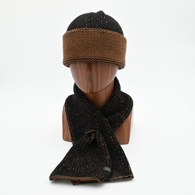 A mannequin wearing a marbled Cuffed Toque in Oxen. The Toque features a silver bean at the crown. This is shown here with a matching Ascot Scarf.