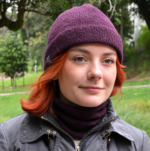 A model wearing a Plumb Milford All-weather toque knitted from 100% merino wool with a waterproof lining, perfect for the outdoors. Paired with a matching Active Infinity Cowl.