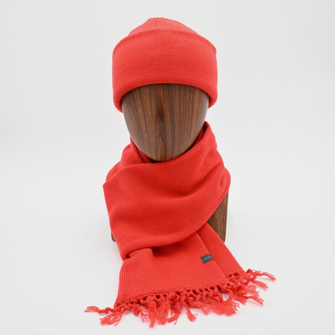 A mannequin wearing a poppy wanaka cuffed toque with a matching tassel scarf.