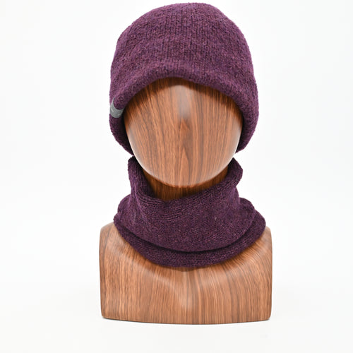 A model wearing a Plumb Milford All-weather toque knitted from 100% merino wool with a waterproof lining, perfect for the outdoors. Paired with an Active Infinity Cowl