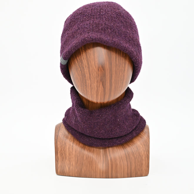 A model wearing a Plumb Milford All-weather toque knitted from 100% merino wool with a waterproof lining, perfect for the outdoors. Paired with an Active Infinity Cowl