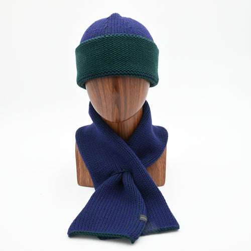 A mannequin wearing a marbled Cuffed Toque in Oxen. The Toque features a silver bean at the crown. This is shown here with a matching Ascot Scarf.